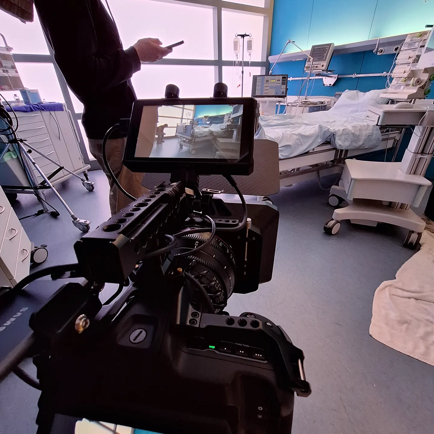 Dreharbeiten in einem Krankenhaus-Set mit medizinischen Requisiten und Filmcrew im Einsatz.