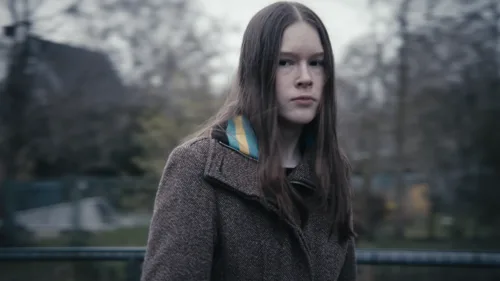 Portrait einer Person mit starkem, selbstbewusstem Blick direkt in die Kamera, der Charakter steht im Mittelpunkt der Szene.