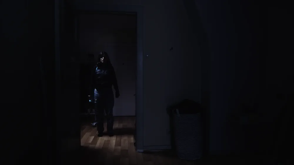 Eine wenig beleuchtete Gestalt im Türrahmen