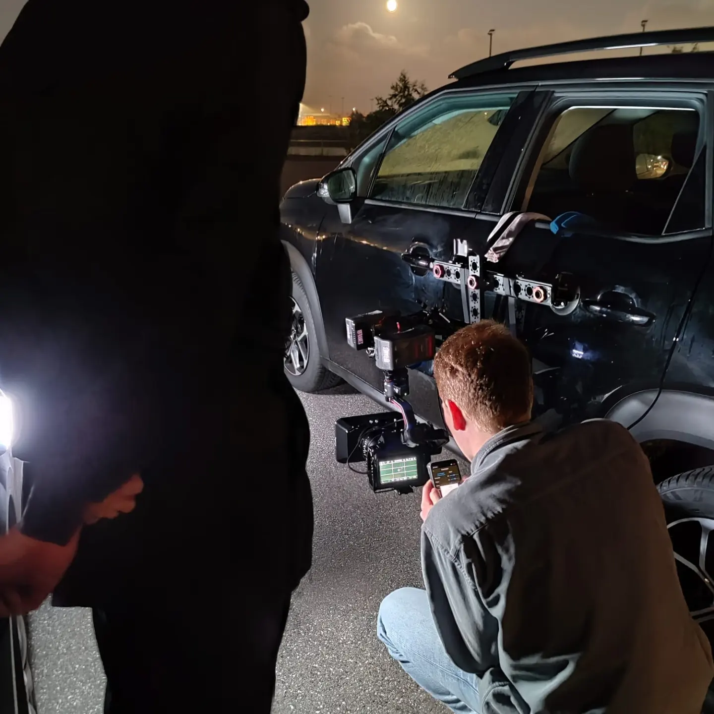 Nachtdreh mit Auto und Kamera-Setup, das Fahrzeug ist für dynamische Aufnahmen mit Filmtechnik ausgestattet.